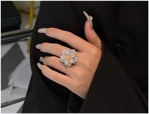 Detailed close-up of a large multi-layer floral ring with pave-set stones on a model