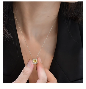 Gros plan d'un collier en argent avec diamant jaune carré porté par un mannequin