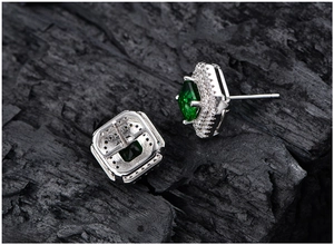Detail view of square emerald stud earrings with micro-pave halo and silver pin structure