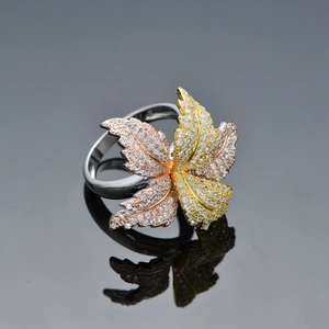 Elegant tri-color petal leaf ring with sparkling crystals on a reflective background