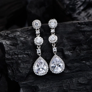 Elegant S925 silver pear-cut drop earrings with halo diamond setting on charcoal background