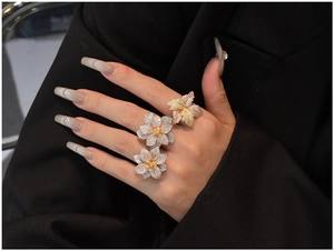 Detailed close-up of a tricolor flower ring with cubic zirconia on a model hand