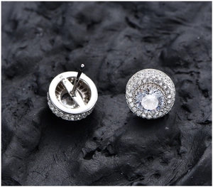Gros plan du poinçon S925 sur des boucles d'oreilles rondes pavées en argent et zircone