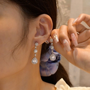 Elegant 925 silver pear-shaped drop earrings with brilliant tassel stones on model
