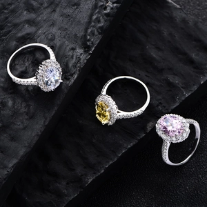 Three oval cut halo rings with pink yellow and white stones on black rock base