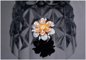 Macro view of two-tone flower ring featuring micro-pave cubic zirconia on dark background