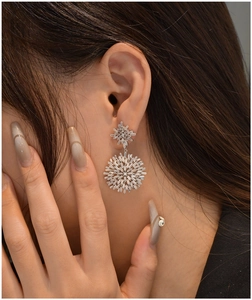 Detail of silver snowflake stud earrings featuring baguette and round cubic zirconia