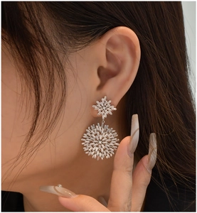 Close-up of S925 silver snowflake earrings with radiant baguette-cut crystals on model