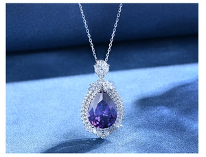 Macro shot of luxury pear-cut purple gemstone pendant with double halo diamond setting