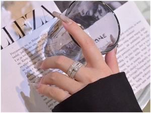 Close-up of stacked 925 silver rings with round brilliant cut center stone and baguette diamonds