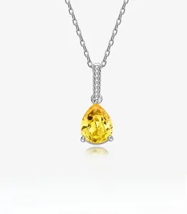 Macro detail of teardrop yellow gemstone pendant with pave-set accents on silver chain