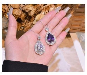 Close-up of teardrop-shaped purple and clear crystal pendants with sparkling rhinestones