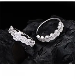 Macro shot of S925 silver wavy rings with micro-pave crystals on dark background