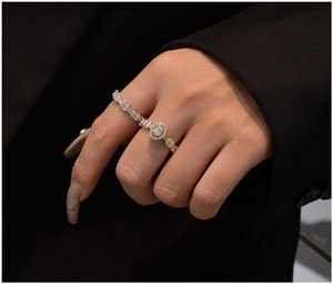 Macro d'une bague de fiançailles halo en argent 925 avec zircons sur le doigt d'un modèle