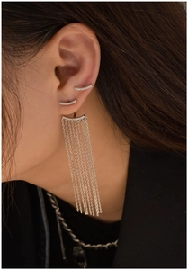 Detailed close-up of asymmetrical long silver tassel earrings with sparkling zircon inlay