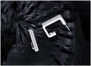 Close-up of S925 sterling silver rectangular earrings with micro-pave crystals on charcoal