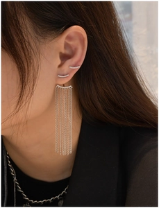 Close-up of asymmetrical long tassel earrings and pavé studs in S925 sterling silver