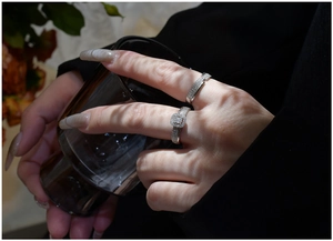 Macro shot of silver S925 stacking rings featuring pavé crystals on a model's hand