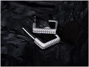 Close-up of square C-shaped S925 silver earrings with double row pavé zircons