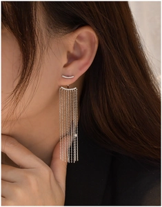 Macro shot of long silver tassel earrings with sparkling crystals and drop chain detail
