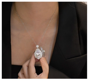 Close-up of a pear-cut purple stone pendant with double halo on a silver chain