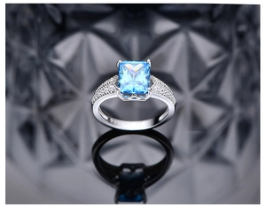 Detailansicht eines großen blauen Edelsteinrings mit zirkonbesetztem Silberband
