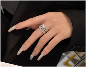 Detail eines S925 Silber Halo Ring-Sets mit Mikro-Pavé-Kristallen an der Hand eines Models