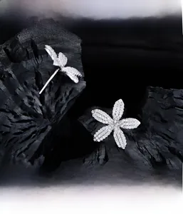 Détail macro de boucles d'oreilles fleurs en micro-pavage avec cristaux sertis