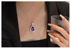 Detailed view of water drop purple crystal pendant on 925 silver necklace on a model