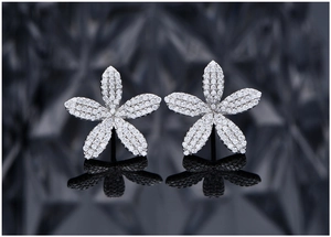Vue macro de boucles d'oreilles fleur en argent avec micro-pavé de cristaux blancs