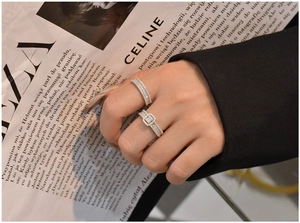Detailed view of stacked S925 silver rings with square cluster and pave diamonds on hand