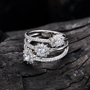 Bague multicouche en argent 925 avec flocons et diamants pavés sur fond de bois noir