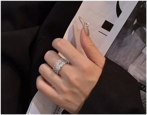 Detail of stacked S925 silver rings with wavy edges and micro-pave cubic zirconia