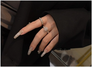 Detail of S925 silver chain rings set with rectangular stones on a dark fabric