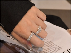 Detail of stacked 925 silver rings with full pavé cubic zirconia and vintage square setting