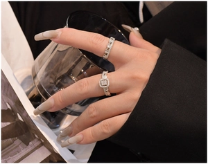 Detailed close-up of a silver halo ring set with square-cut stone and pavé band