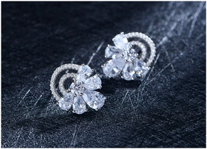 Macro shot of S925 silver half-arc floral stud earrings with sparkling zircon stones