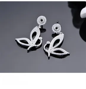 Gros plan de boucles d'oreilles papillon en argent avec zircone micro-incrustée sur miroir