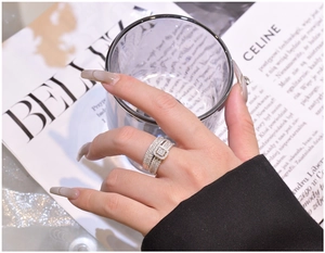 Detail of stacked S925 silver rings with full pavé diamonds on a hand model
