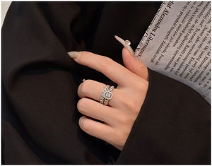 Detail of S925 silver twist ring with emerald-cut zirconia on a woman's hand