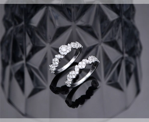 Close-up of S925 silver wedding ring set with micro-pave cubic zirconia on black mirror