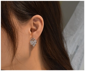 Detail of S925 silver arc cluster earrings with pear and round diamonds on model