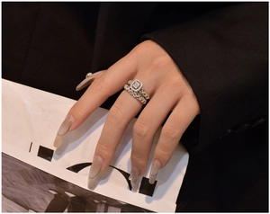 Close-up of S925 silver ring set with rectangle gemstone and braided band on finger
