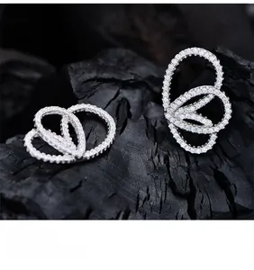 Vue macro de boucles d'oreilles ailes de papillon avec zircons blancs et plaqué argent