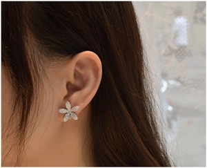 Gros plan de boucles d'oreilles fleur élégantes avec micro-pavé de zircons sur modèle