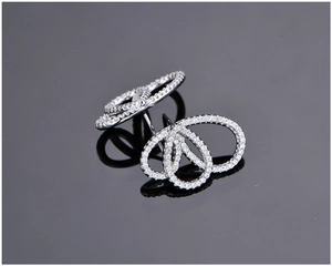 Vue macro de boucles d'oreilles en argent avec cristaux scintillants au design C croisé