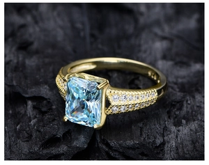 Macro shot of S925 engraving on a yellow gold ring with a large ice-cut blue gem