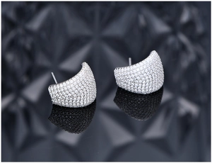 Macro view of micro-paved zircon curved stud earrings with polished 925 silver finish