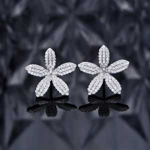 Boucles d'oreilles fleurs en argent serties de zircons sur fond sombre artistique