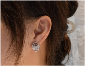 Detailed close-up of a S925 silver fan-shaped earring with zircon stones on a model ear